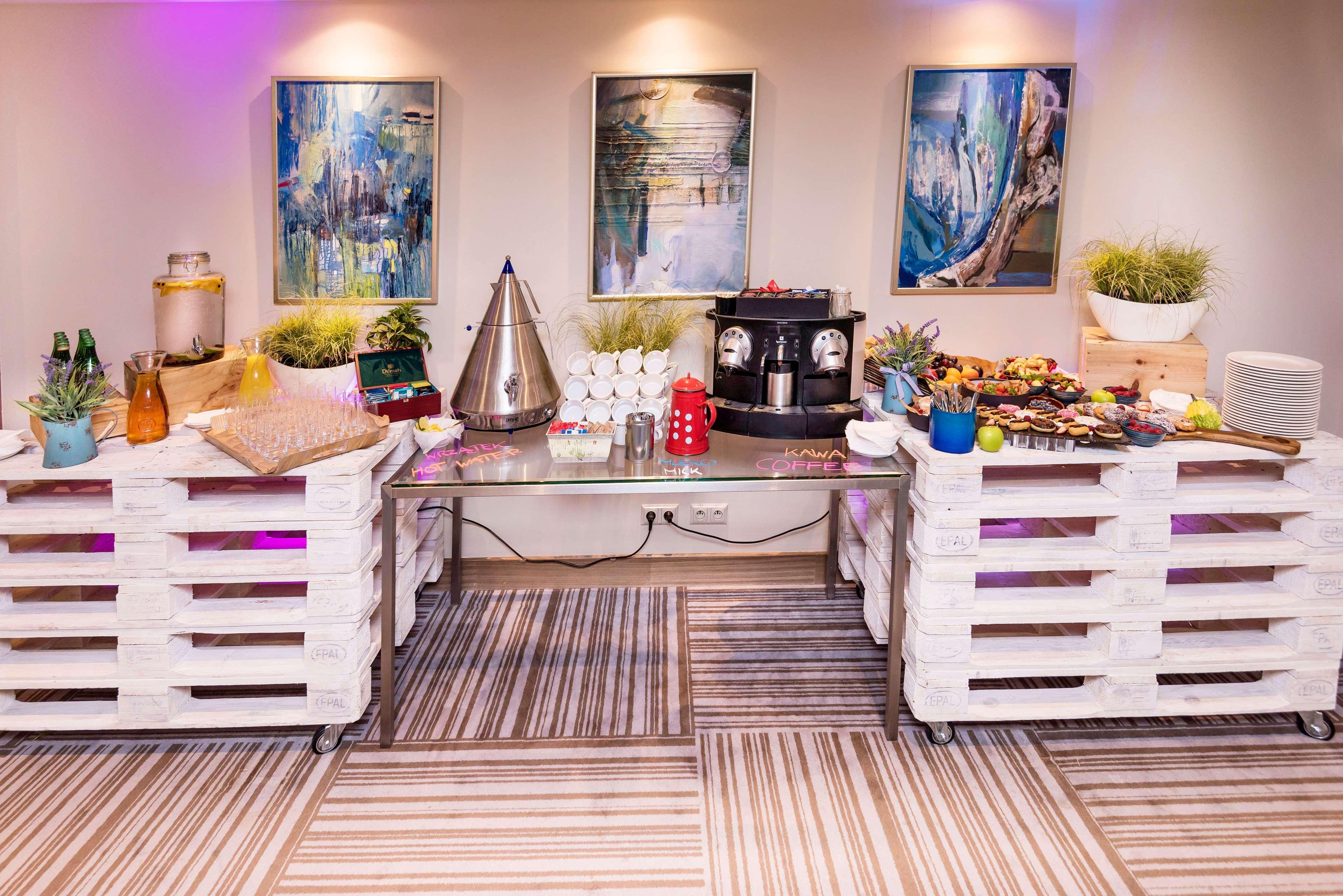 Radisson Blu Hotel Krakow Exterior photo The image depicts a setup designed for an event or gathering. In the foreground, there are two white pallets used as tables, each adorned with various items. On the left, there are beverages in bottles and a decorative container, alongside a small co