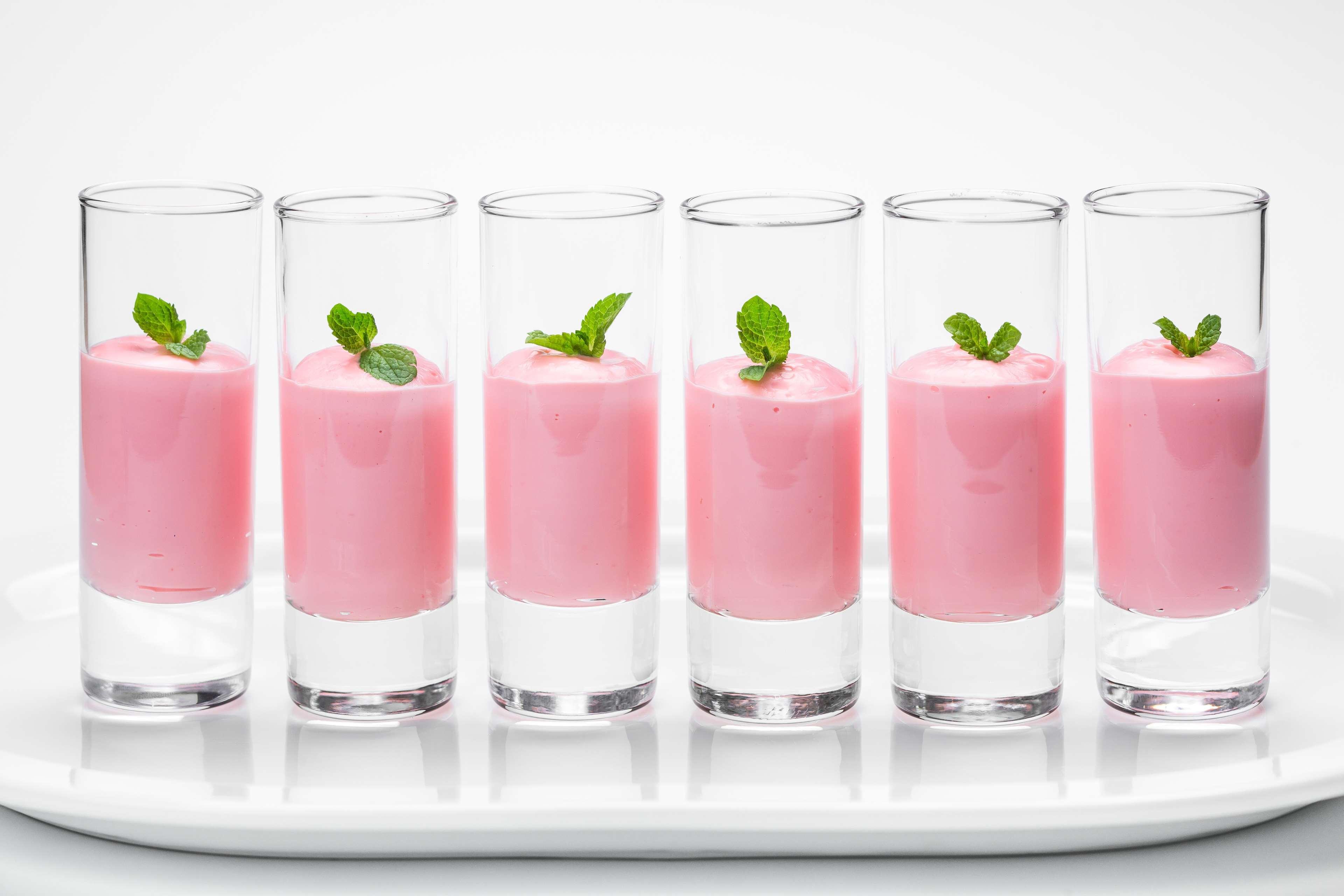 Radisson Blu Hotel Krakow Exterior photo The photo shows a row of six clear shot glasses filled with a pink creamy dessert or drink. Each glass is topped with a small sprig of fresh mint, giving a decorative touch. The glasses are arranged neatly on a white plate, creating a clean and appea