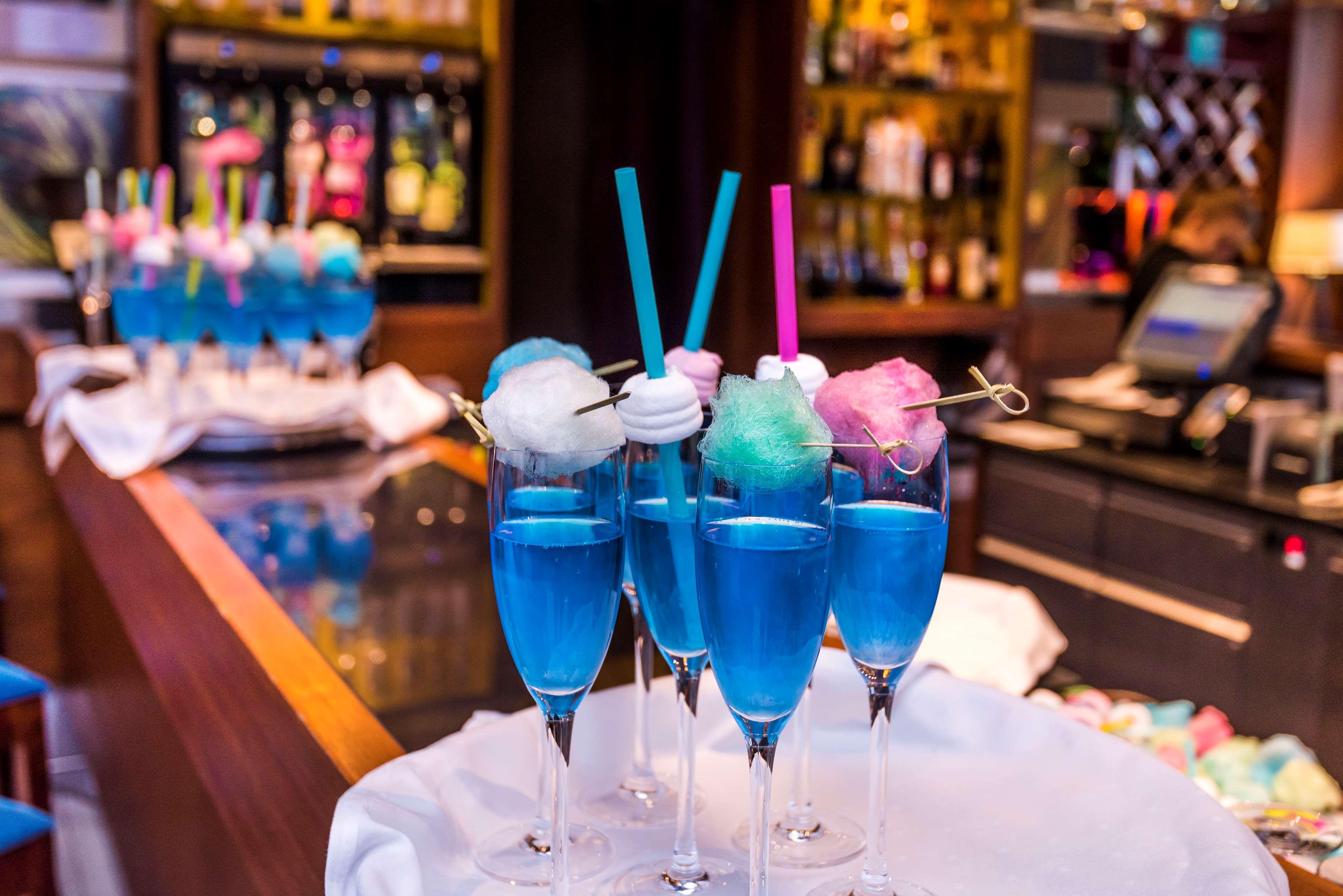 Radisson Blu Hotel Krakow Exterior photo The photo shows a vibrant display of cocktails in tall glasses. Each drink is bright blue and garnished with colorful cotton candy on top, creating a whimsical appearance. Some glasses have straws—one pink and one blue—adding to the playful presentat